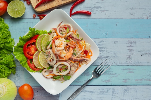 Ensalada picante de mariscos mixtos con ingredientes de comida tailandesa.