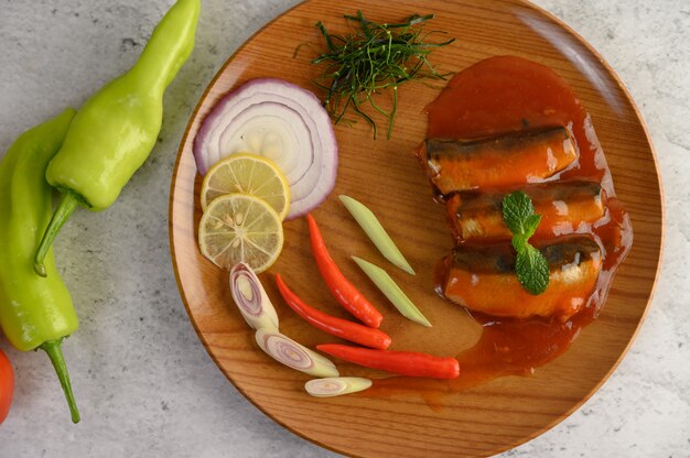 Ensalada picante de sardina en salsa de tomate en bandeja de madera