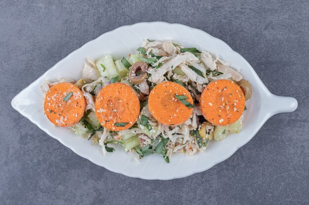 Ensalada de pollo en cubitos en un plato en forma de hoja.