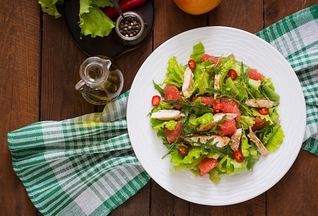 Ensalada de pollo fresco, pomelo, lechuga y aderezo de miel y mostaza. Menú dietético Nutrición apropiada. Vista superior