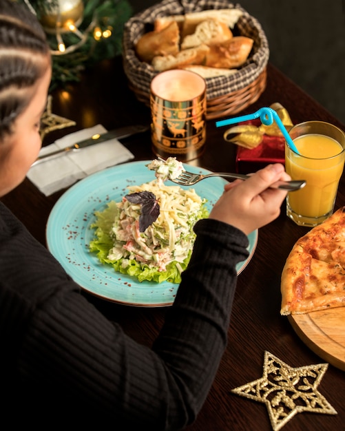 Ensalada de pollo con mayonesa y un vaso de jugo de naranja