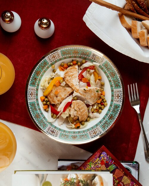 Ensalada de pollo con pimientos guisantes y zanahorias vista superior