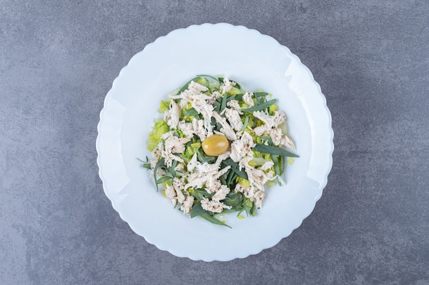 Ensalada de pollo en rodajas en un plato blanco.