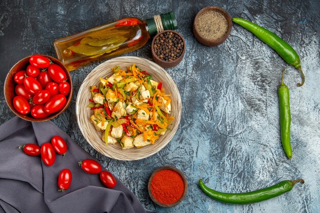 Ensalada de pollo con verduras de vista superior con tomates en la mesa de luz