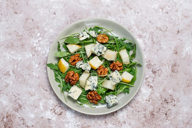 Ensalada de queso azul con nuez y ruccola y aceite de oliva y rodajas de pera