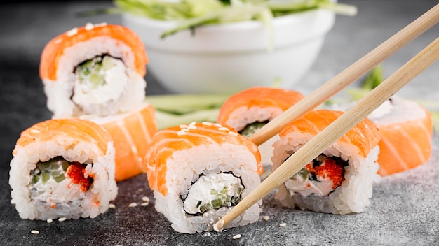 Ensalada y rollos de sushi frescos y palillos