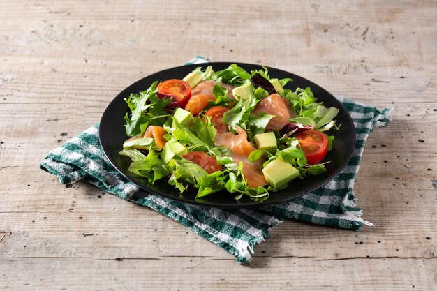 Ensalada de salmón y aguacate en mesa de madera rústica