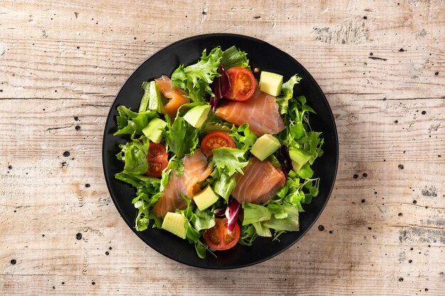 Ensalada de salmón y aguacate en mesa de madera rústica