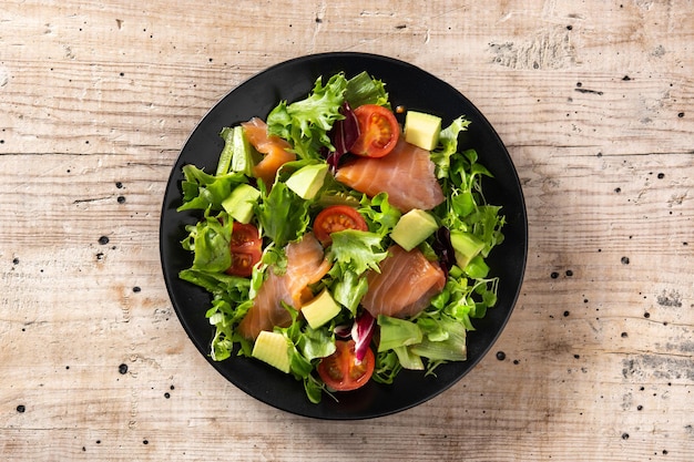 Ensalada de salmón y aguacate en mesa de madera rústica