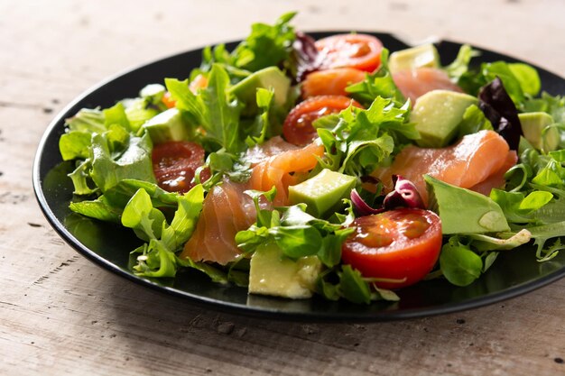 Ensalada de salmón y aguacate en mesa de madera rústica