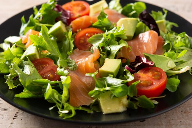 Ensalada de salmón y aguacate en mesa de madera rústica