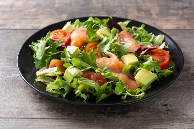 Ensalada de salmón y aguacate en mesa de madera