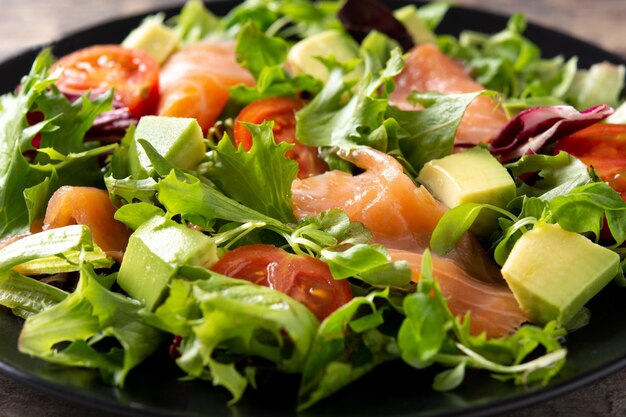 Ensalada de salmón y aguacate en mesa de madera