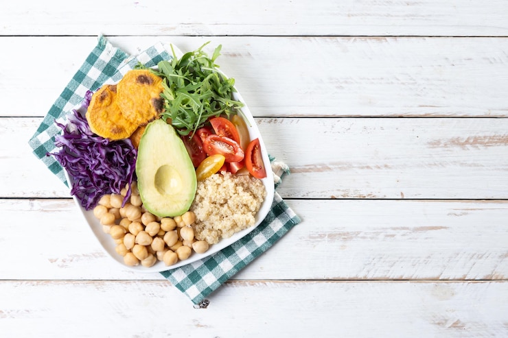 Foto gratuito una ensalada saludable con aguacate, tomate y garbanzos en una mesa de madera