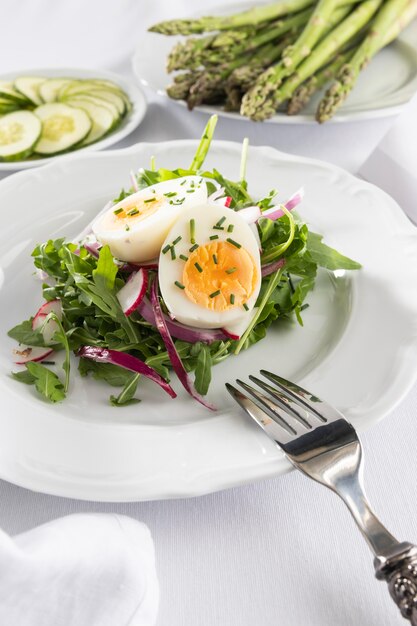 Ensalada saludable con huevo en una composición de plato blanco