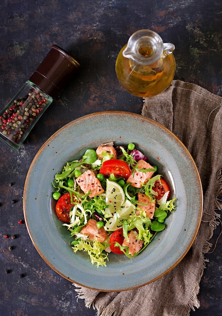 Ensalada saludable con pescado. Salmón al horno, tomate, lima y lechuga. Cena Saludable. Endecha plana. Vista superior