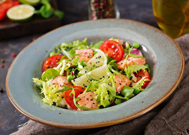 Ensalada saludable con pescado. Salmón al horno, tomate, lima y lechuga. Cena Saludable.