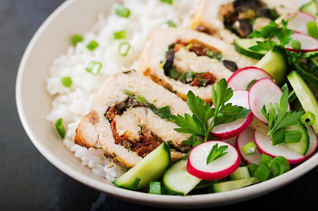 Ensalada saludable con rollitos de pollo, rábanos, pepino, cebolla verde y arroz. Nutrición apropiada.