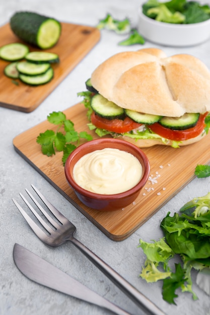 Ensalada con sándwich y mayonesa sobre tabla de cortar