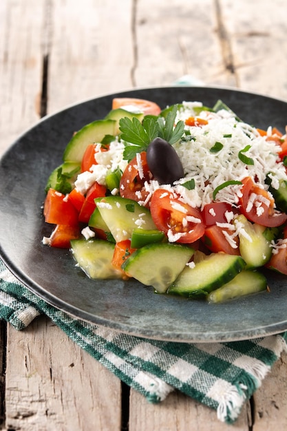 Foto gratuita ensalada shopka tradicional búlgara con tomate, pepino y queso sirene búlgaro sobre mesa de madera