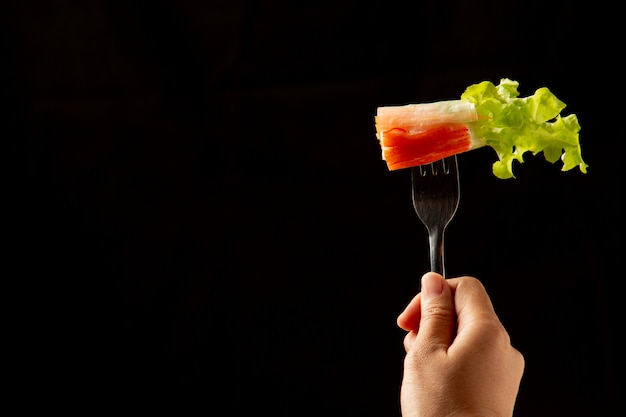 Ensalada tailandesa ajo en cubiertos en la mano