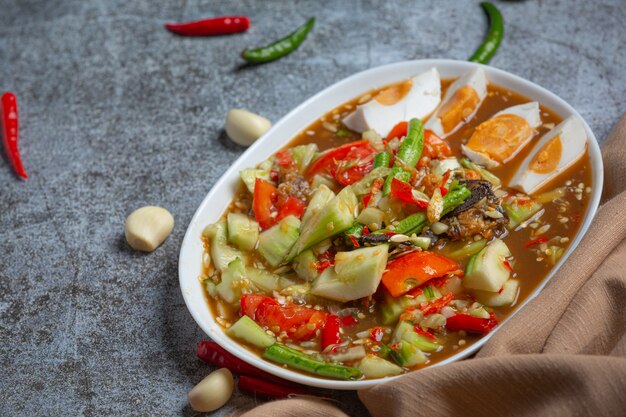 Ensalada tailandesa picante con pepinos y pimientos en huevos salados.