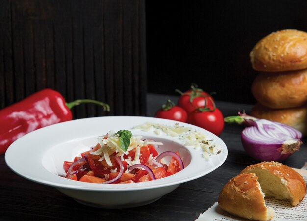 Ensalada de tomate con cebolla y parmesano fresco picado