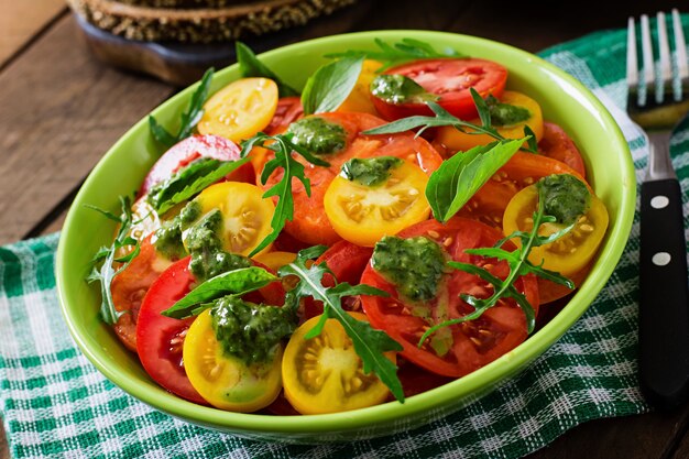 Ensalada de tomate de verano con albahaca, pesto y rúcula