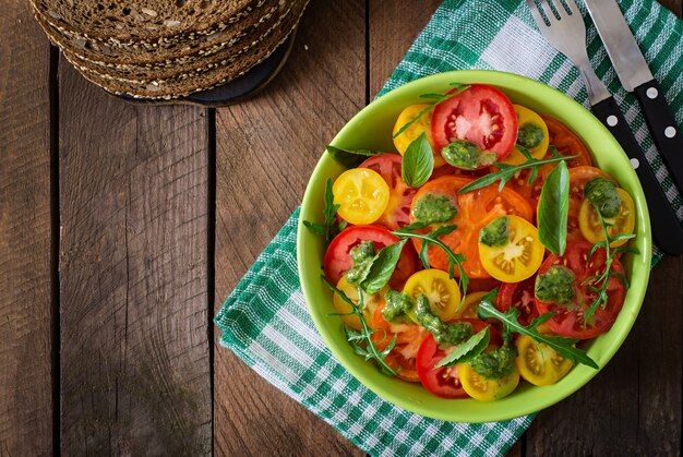 Ensalada de tomate de verano con albahaca, pesto y rúcula