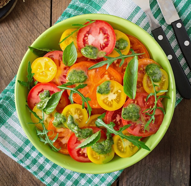 Ensalada de tomate de verano con albahaca, pesto y rúcula