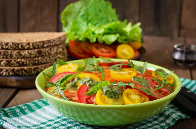 Ensalada de tomate de verano con albahaca, pesto y rúcula