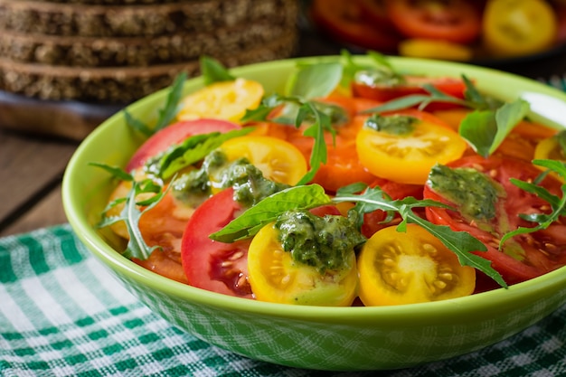 Ensalada de tomate de verano con albahaca, pesto y rúcula