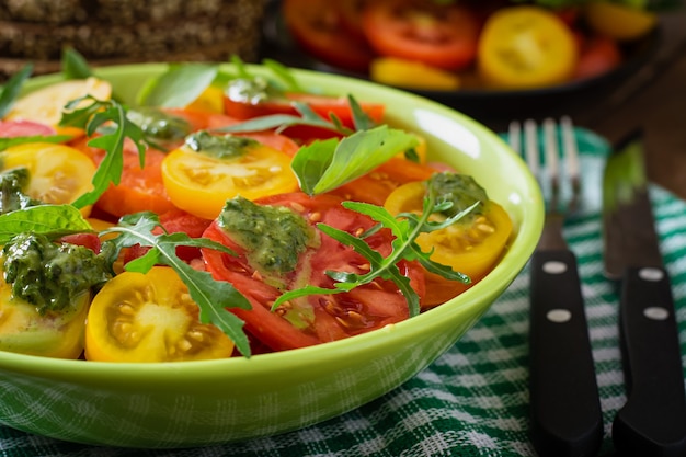 Ensalada de tomate de verano con albahaca, pesto y rúcula