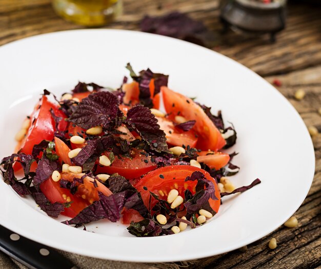 Ensalada de tomates con albahaca violeta y piñones. Comida vegana. Comida italiana