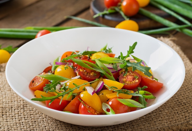 Foto gratuita ensalada de tomates cherry frescos con cebolla y rúcula