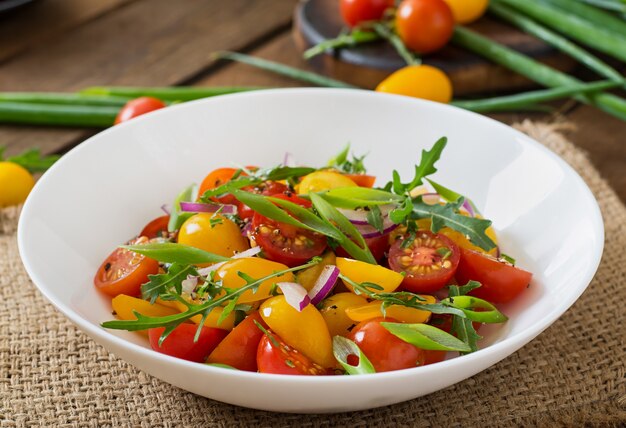 Ensalada de tomates cherry frescos con cebolla y rúcula