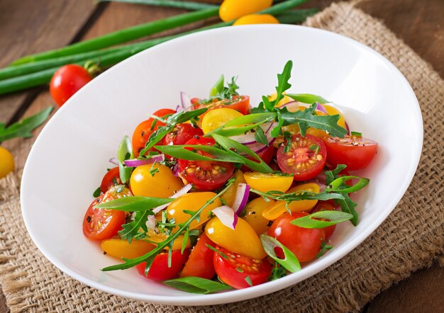 Ensalada de tomates cherry frescos con cebolla y rúcula