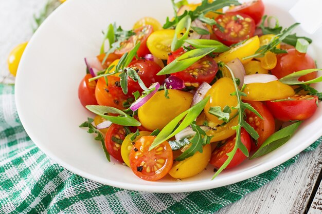 Ensalada de tomates cherry frescos con cebolla y rúcula