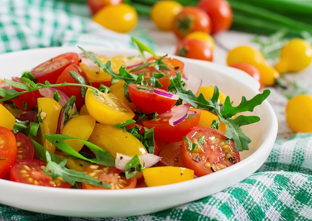 Ensalada de tomates cherry frescos con cebolla y rúcula