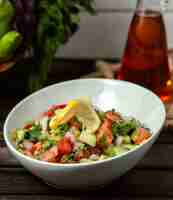 Foto gratuita ensalada de tomates, pepinos, cebollas y verduras en una mesa