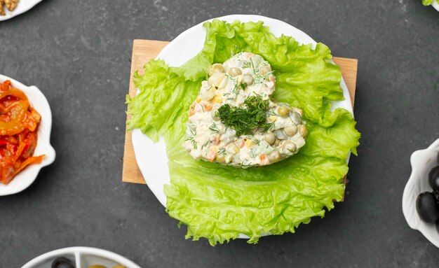 Ensalada tradicional rusa stolichni con lechuga. Vista superior.