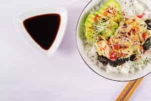 Foto gratuita ensalada vegana con arroz, col de kimchi en escabeche, aguacate, nori y sésamo en un tazón.