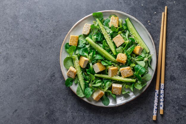 Ensalada vegana con pepino tofu y sésamo servido en plato Primer plano