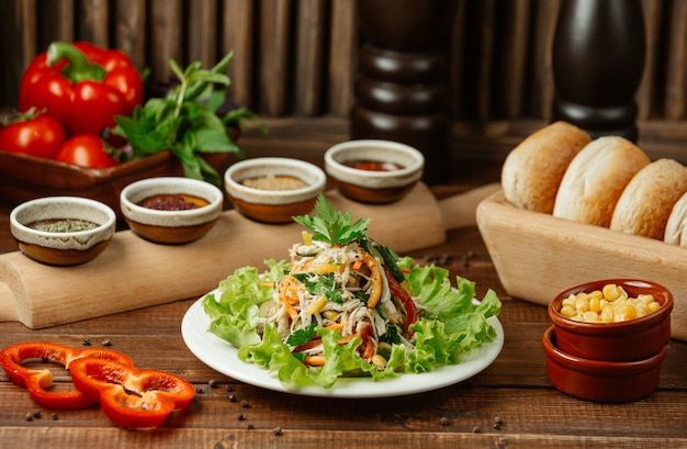 Ensalada de vegetales finamente picada que contiene zanahorias, repollo, tomates, pepino y ensalada