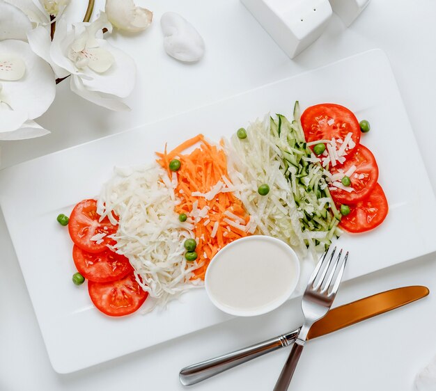 Ensalada de vegetales frescos con vista superior de salsa blanca