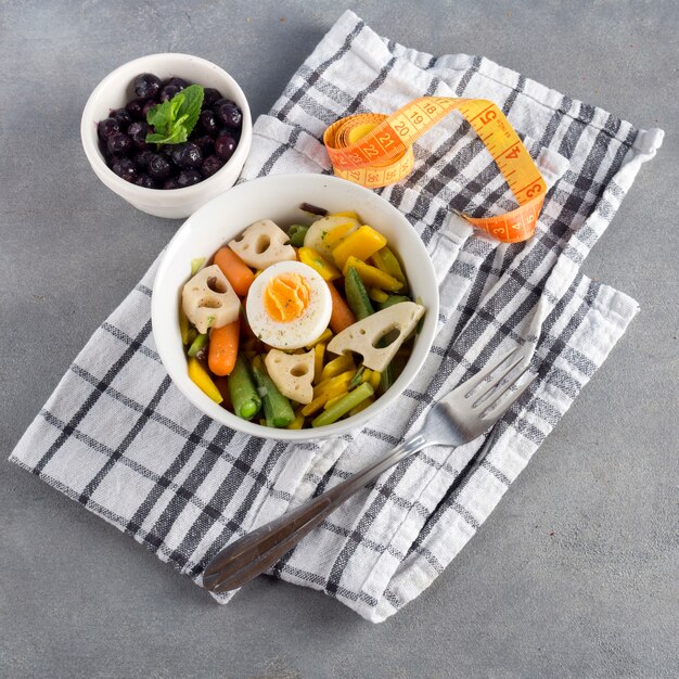 Ensalada vegetariana con bayas y cinta métrica