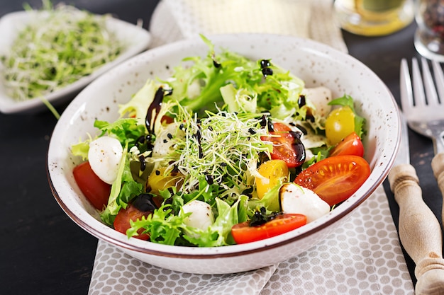 Foto gratuita ensalada vegetariana con tomate cherry, mozzarella y lechuga.