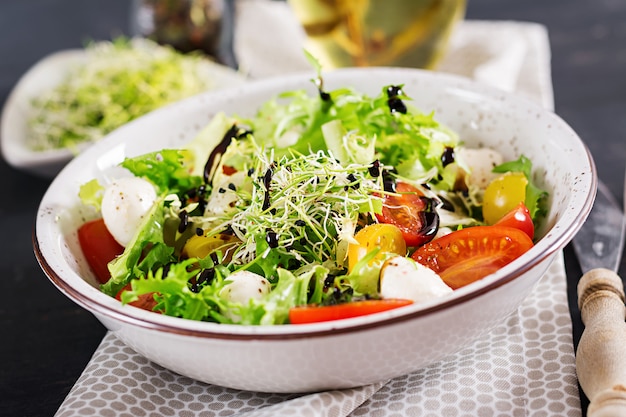 Foto gratuita ensalada vegetariana con tomate cherry, mozzarella y lechuga.