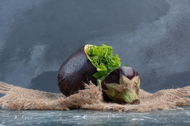 Ensalada verde en berenjena morada tallada.