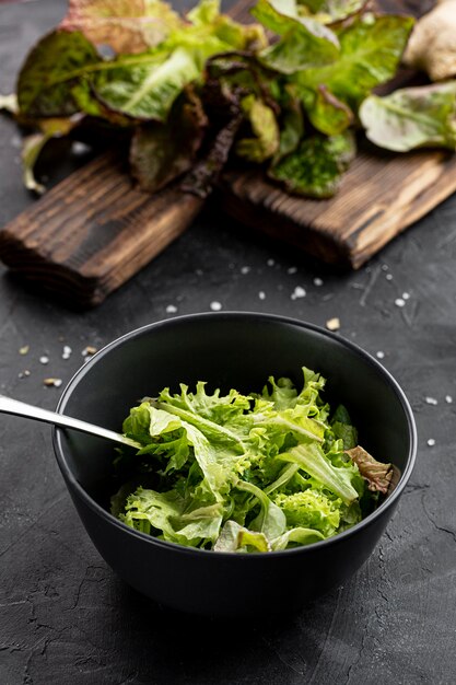 Ensalada verde fresca de alto ángulo en un recipiente oscuro